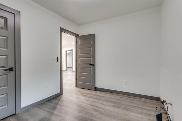 empty room with light wood-type flooring and baseboards