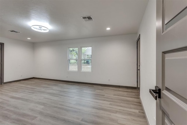 empty room with recessed lighting, baseboards, visible vents, and light wood finished floors