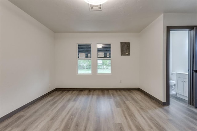 interior space featuring light wood-style floors, baseboards, and visible vents