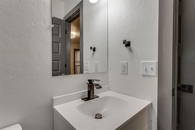 bathroom featuring vanity and a textured wall