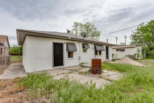 rear view of house with fence and brick siding