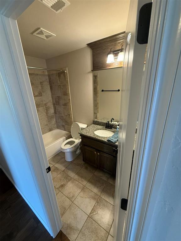 bathroom featuring vanity, tile patterned floors, toilet, and visible vents