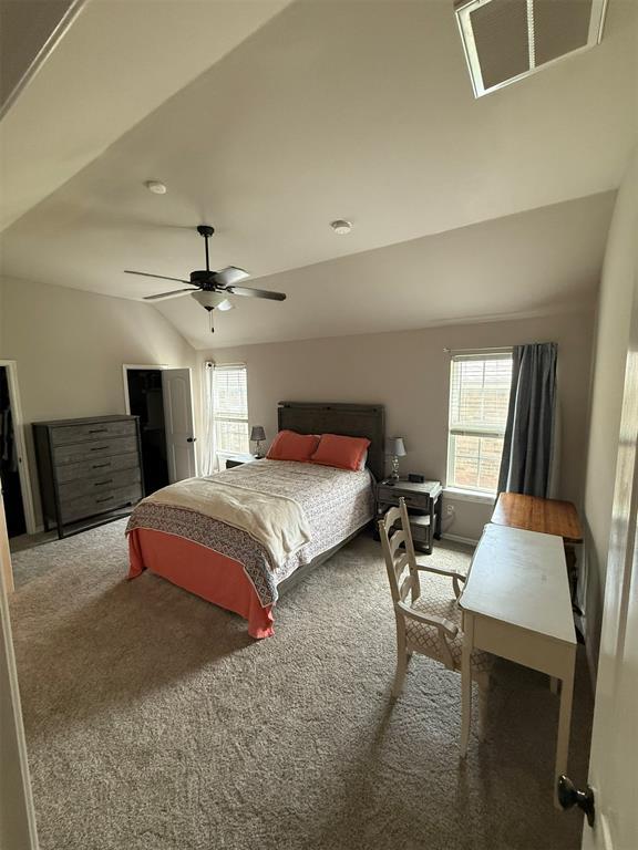 bedroom featuring visible vents, lofted ceiling, baseboards, ceiling fan, and carpet