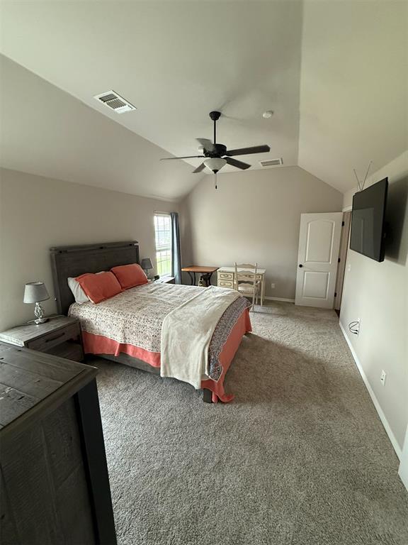 bedroom featuring carpet flooring, baseboards, visible vents, and lofted ceiling