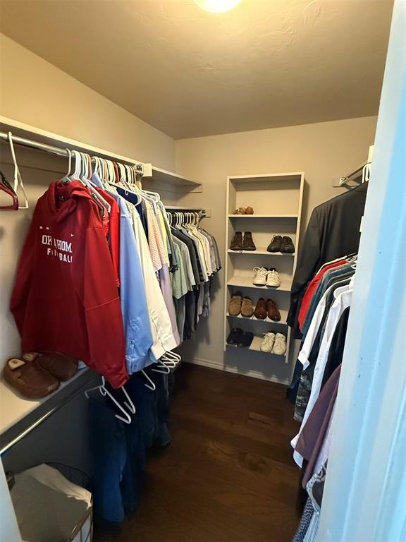 walk in closet with wood finished floors