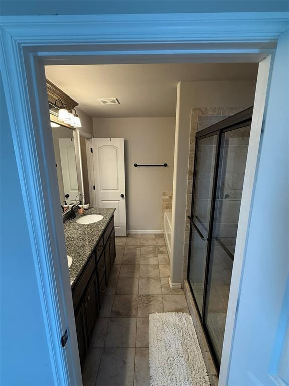 bathroom with double vanity, a bath, visible vents, a shower stall, and a sink