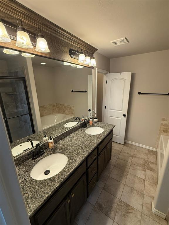full bathroom featuring a garden tub and a sink