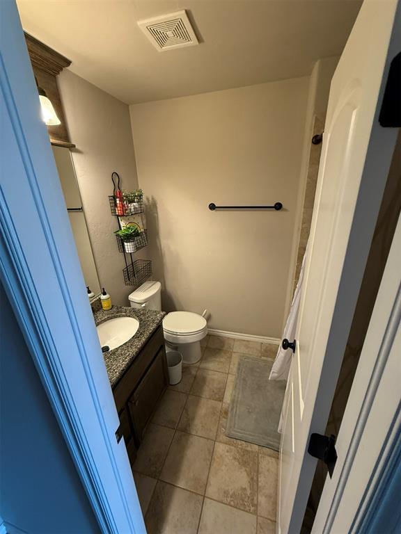 bathroom with visible vents, tile patterned flooring, vanity, baseboards, and toilet