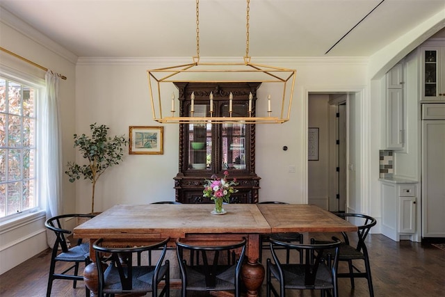 dining area with dark wood-type flooring and crown molding