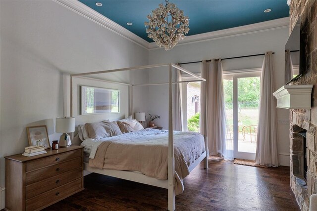 bedroom featuring a stone fireplace, a chandelier, access to exterior, ornamental molding, and dark wood finished floors