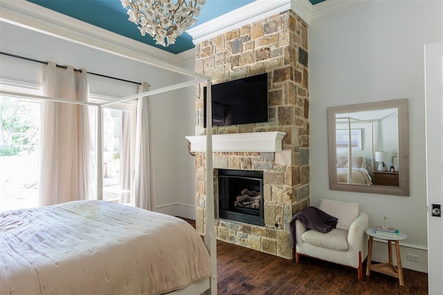 bedroom with a fireplace, crown molding, wood finished floors, and a chandelier