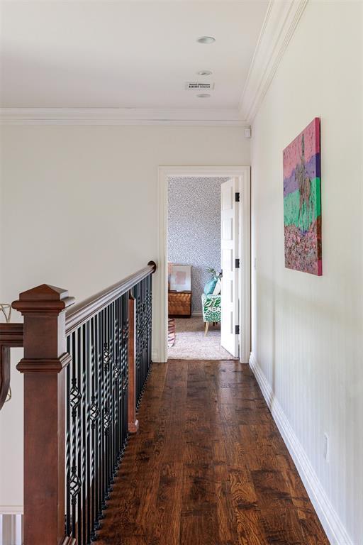 corridor featuring crown molding, wood finished floors, and baseboards