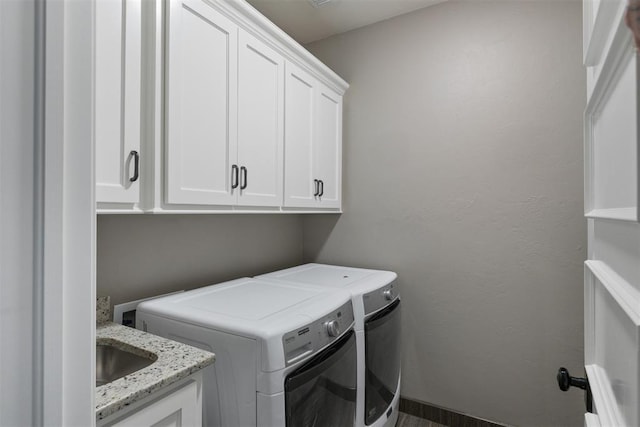 washroom featuring cabinet space and washer and clothes dryer