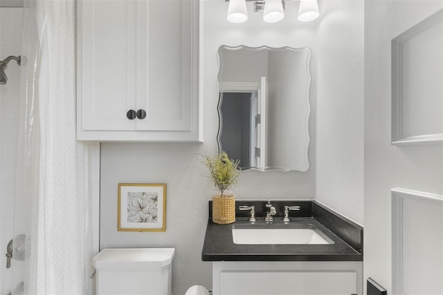 bathroom with toilet, a shower with shower curtain, and vanity