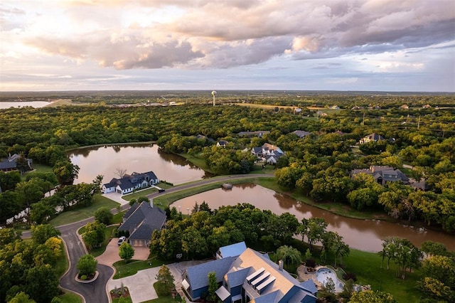 aerial view at dusk of a water view and a residential view