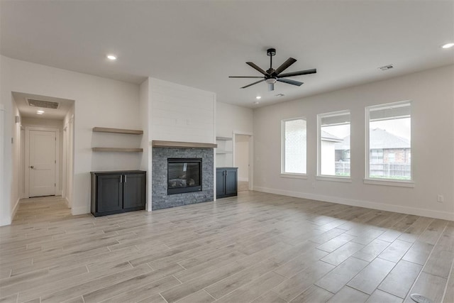 unfurnished living room with baseboards, a ceiling fan, and visible vents