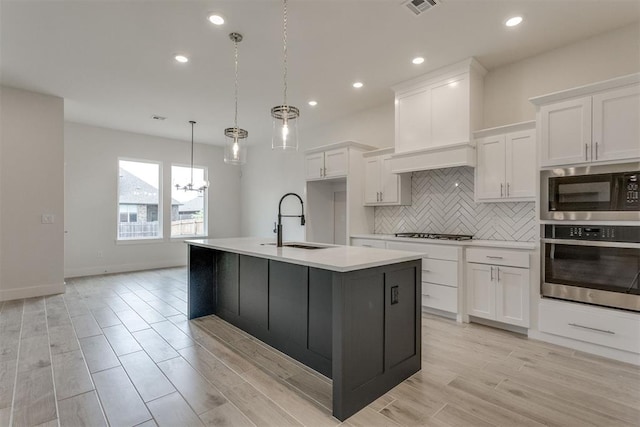 kitchen with gas cooktop, a sink, a chandelier, stainless steel oven, and built in microwave