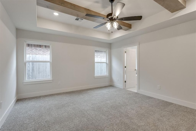 unfurnished room with visible vents, a raised ceiling, ceiling fan, and baseboards