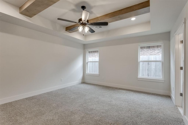 empty room featuring a raised ceiling, baseboards, light carpet, and ceiling fan