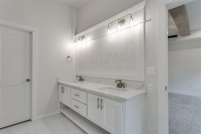 bathroom with a sink, baseboards, and double vanity