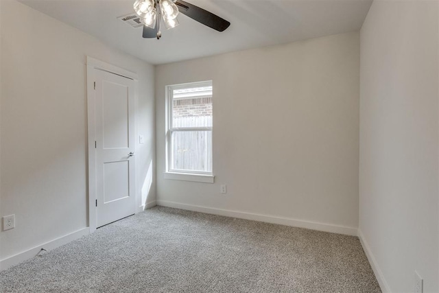 spare room with carpet floors, ceiling fan, visible vents, and baseboards
