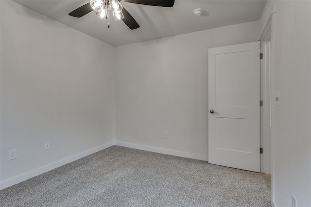 empty room with ceiling fan, light colored carpet, and baseboards