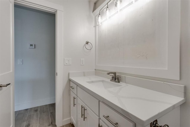 bathroom featuring vanity, baseboards, and wood finished floors