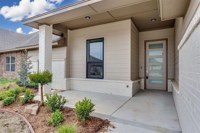 doorway to property featuring brick siding