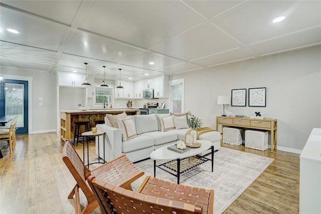 living area with recessed lighting, light wood finished floors, and baseboards