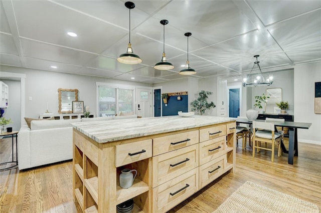kitchen with open shelves, light stone counters, light brown cabinets, light wood-style flooring, and decorative light fixtures