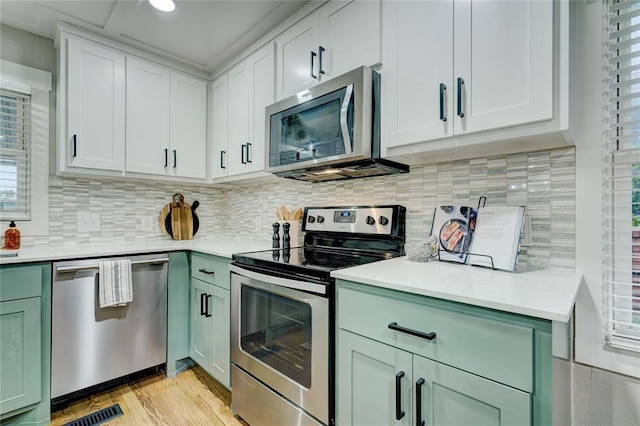 kitchen with light countertops, green cabinets, and stainless steel appliances