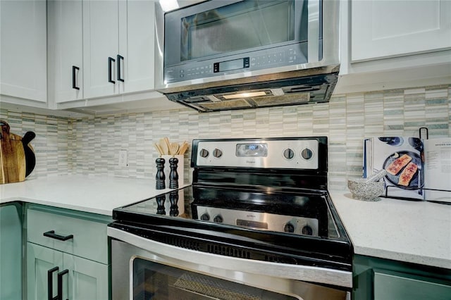 kitchen featuring appliances with stainless steel finishes, white cabinets, and tasteful backsplash