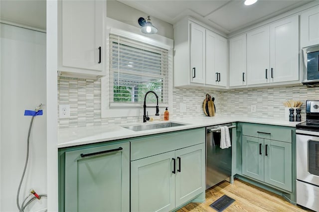 kitchen featuring visible vents, light countertops, a sink, appliances with stainless steel finishes, and green cabinets