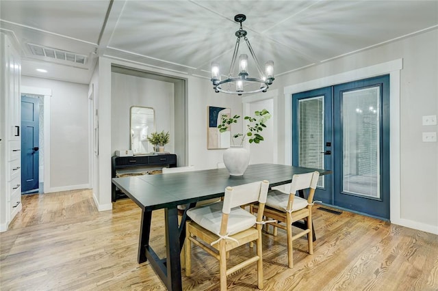 dining room featuring light wood-style floors, a notable chandelier, and visible vents