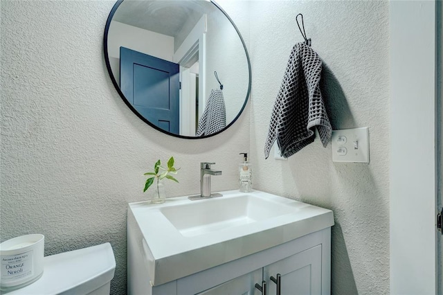 bathroom featuring vanity and a textured wall