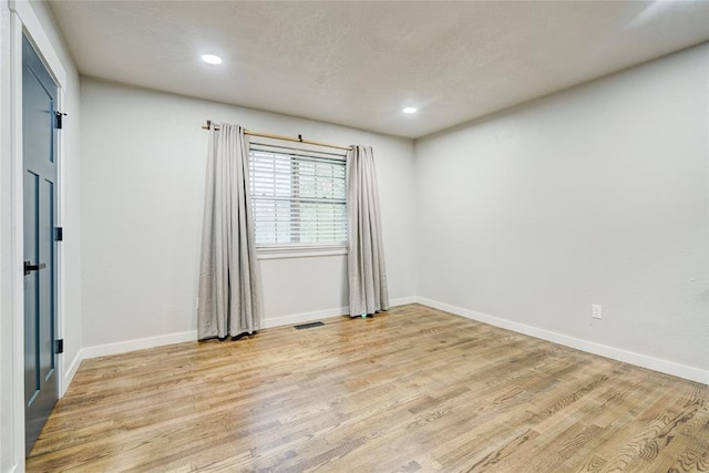 unfurnished room featuring baseboards, recessed lighting, and light wood-style flooring