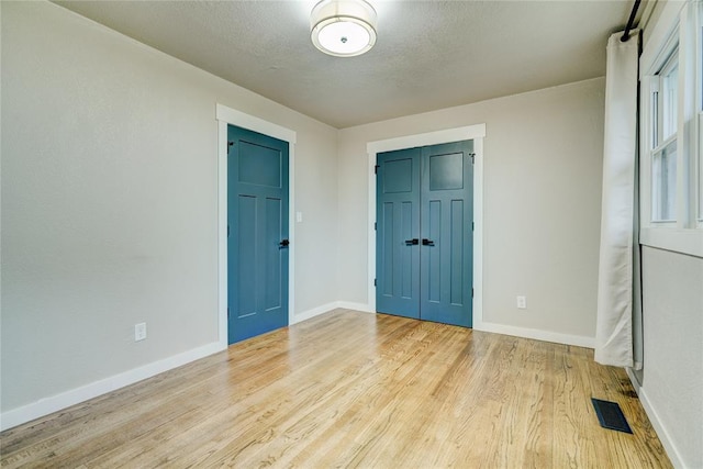 interior space with baseboards, wood finished floors, and visible vents