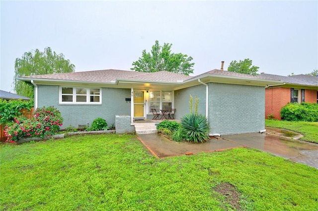 46 E 14th St, Edmond, OK 73034 - single story home with brick siding, a front lawn, and covered porch