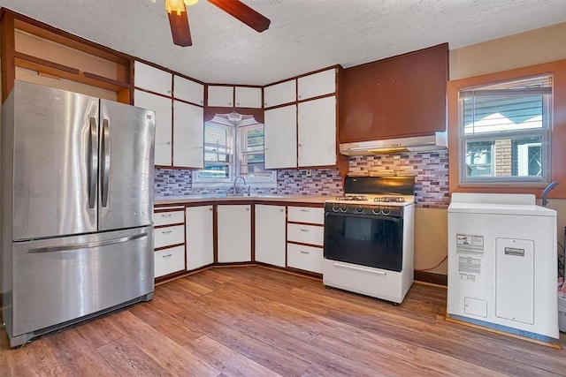 kitchen featuring ceiling fan, a textured ceiling, freestanding refrigerator, white range with gas cooktop, and under cabinet range hood