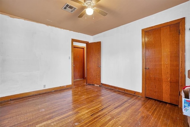 unfurnished bedroom featuring visible vents, a ceiling fan, baseboards, and hardwood / wood-style floors