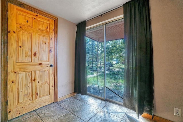 doorway to outside with baseboards and a wealth of natural light