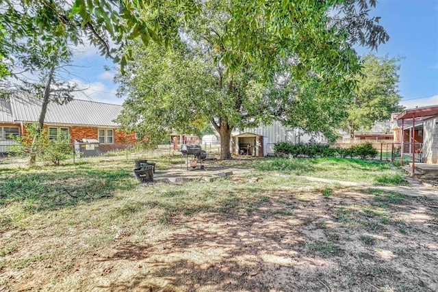 view of yard with an outdoor structure, fence, and a shed