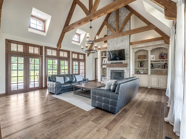 living room featuring an inviting chandelier, a fireplace, high vaulted ceiling, french doors, and a wealth of natural light