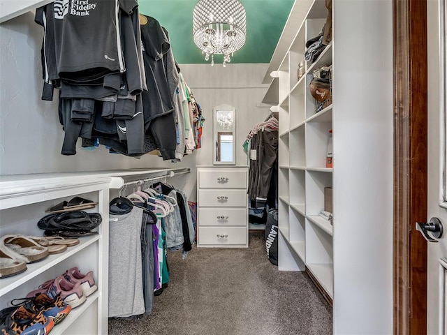 spacious closet featuring an inviting chandelier and carpet flooring