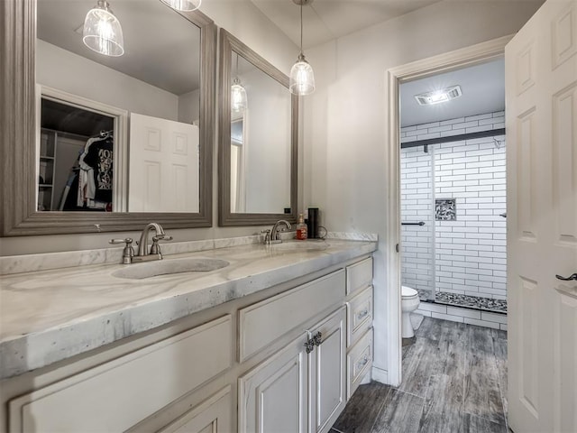 bathroom with double vanity, a sink, a stall shower, and visible vents