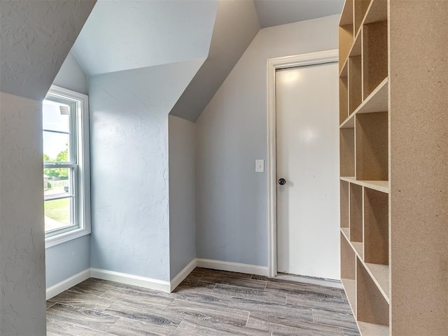 bonus room featuring wood finished floors, baseboards, and lofted ceiling