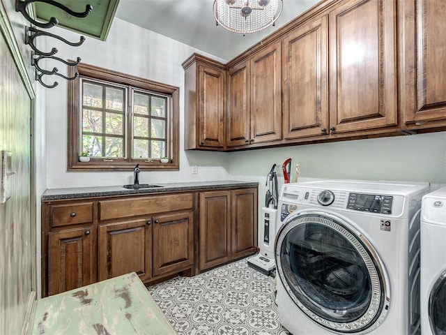 laundry area featuring a sink, washer and clothes dryer, and cabinet space