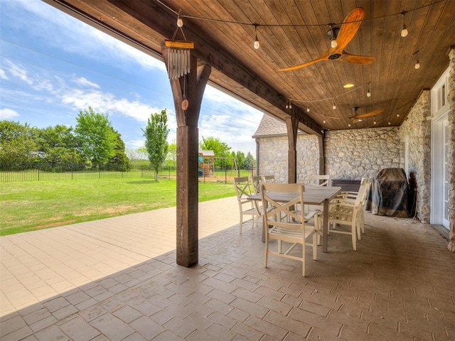 view of patio / terrace with ceiling fan, outdoor dining area, a fenced backyard, and a playground