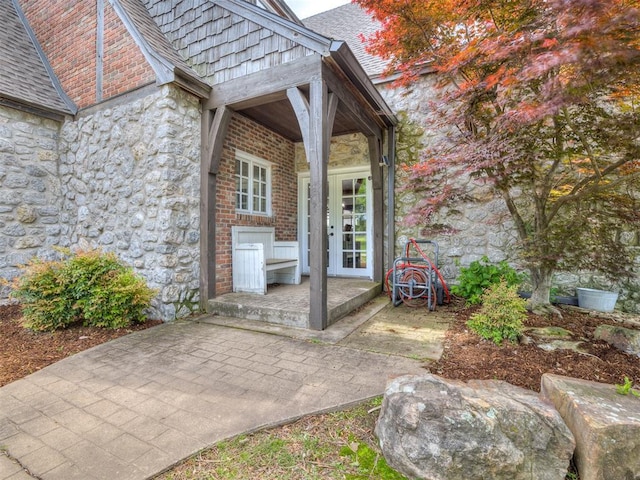 exterior space with french doors and stone siding