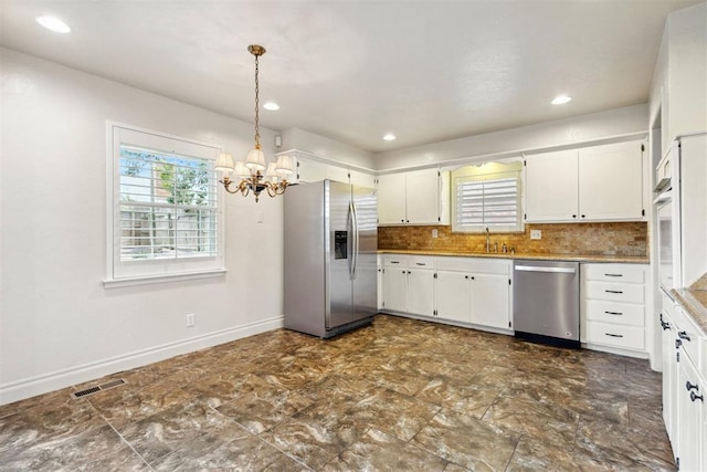 kitchen featuring visible vents, white cabinetry, a sink, appliances with stainless steel finishes, and a notable chandelier